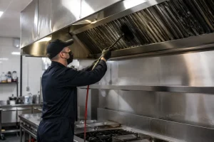 Commercial kitchen technician servicing exhaust hood